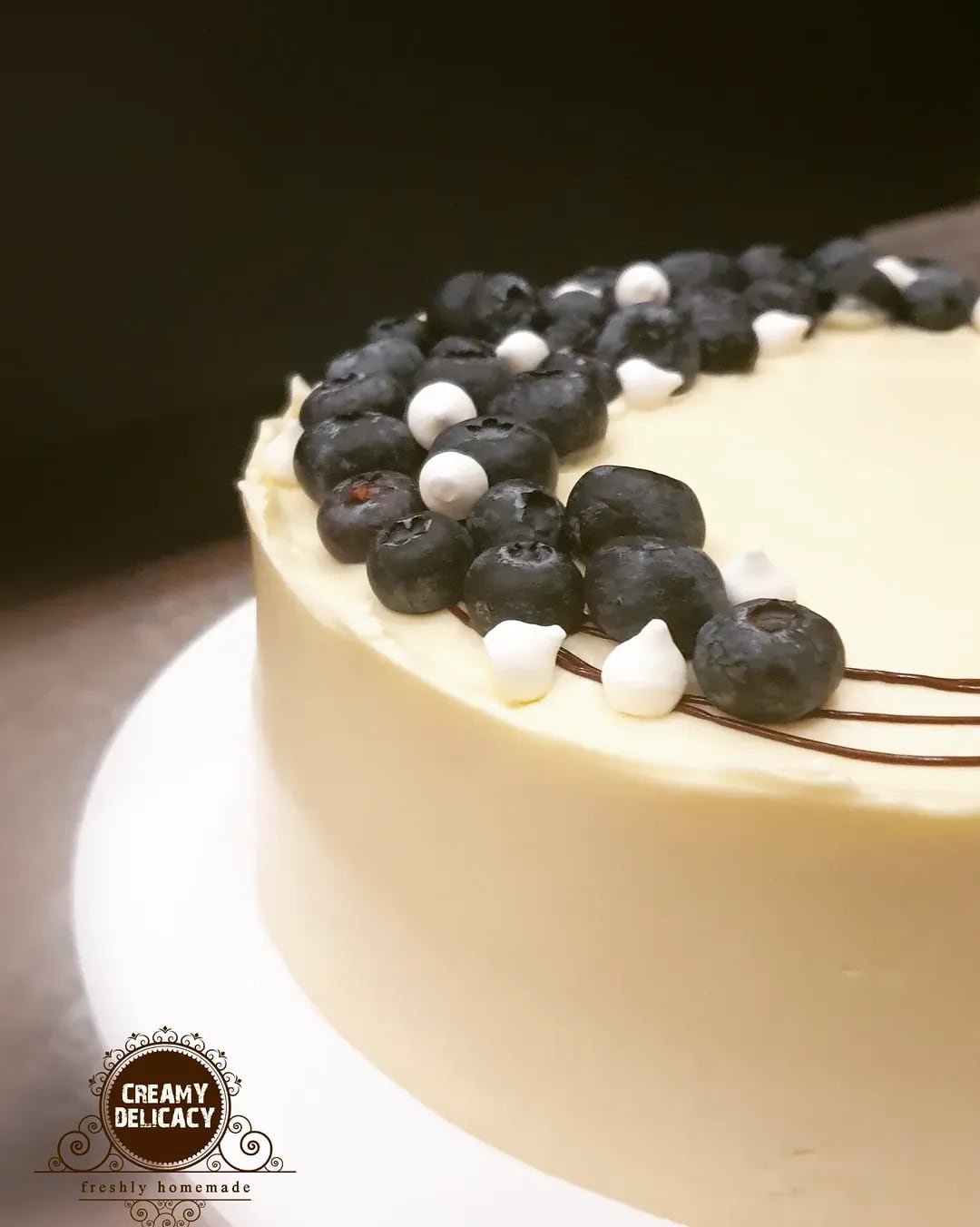 Lemon blueberry cake finished with a crescent of blueberries