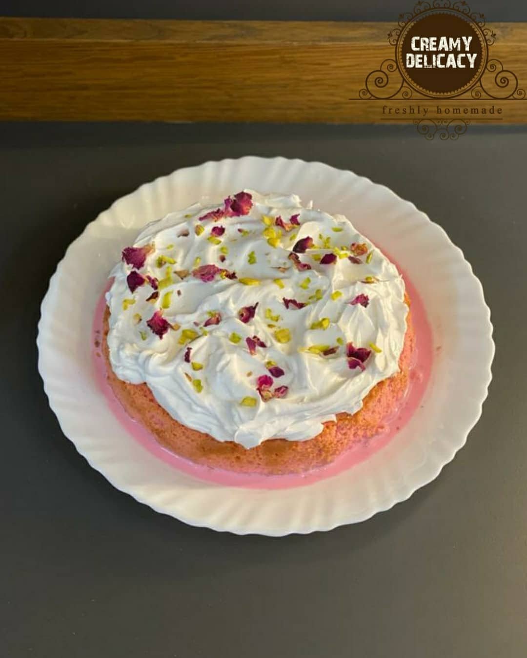 Rose milk cake topped with chantilly, pistachios and rose petals