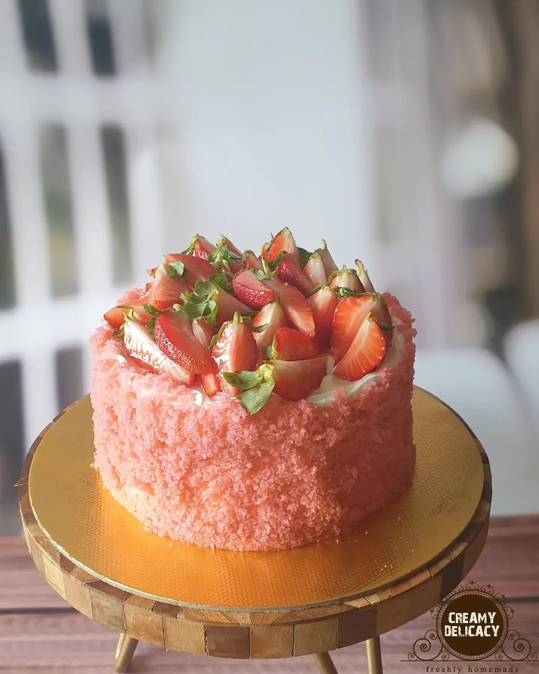 Strawberry pink velvet cake topped with fresh strawberries